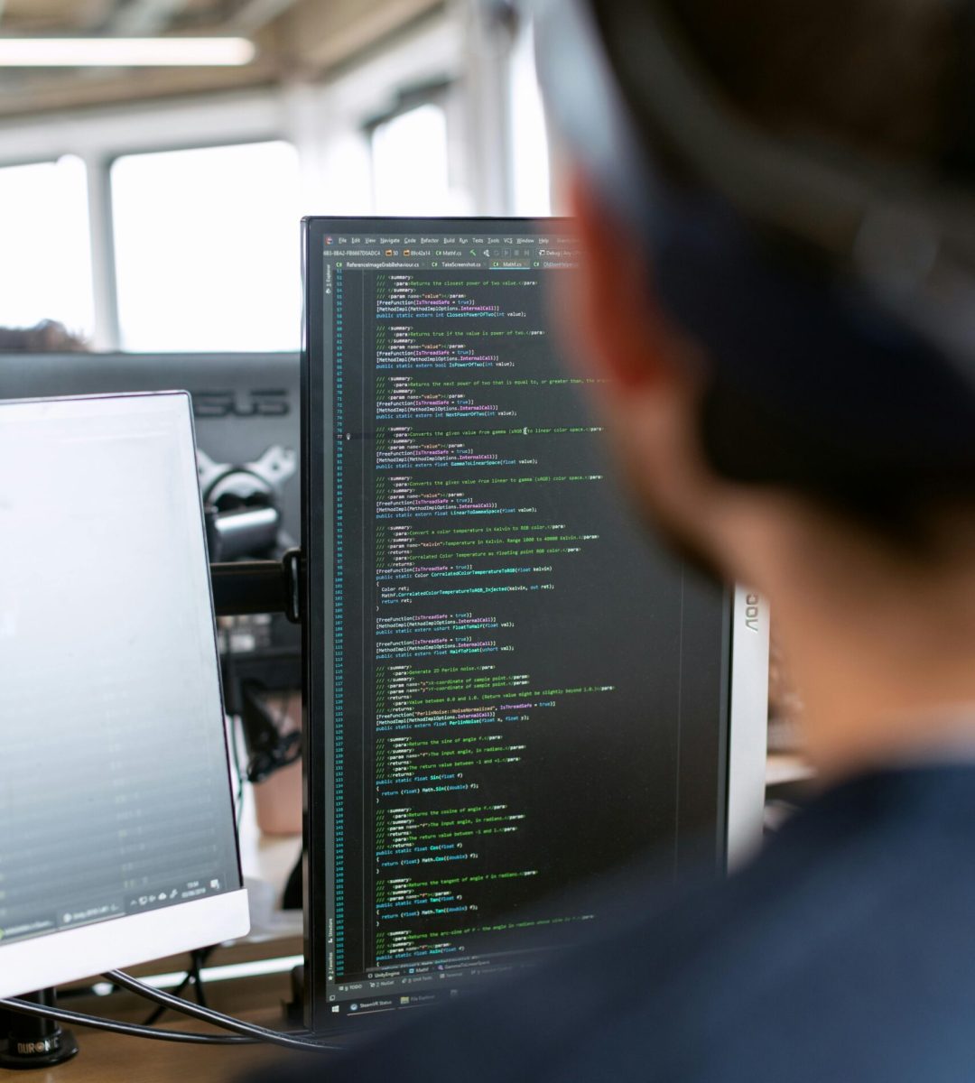 A male software engineer working on code in a modern office setting.